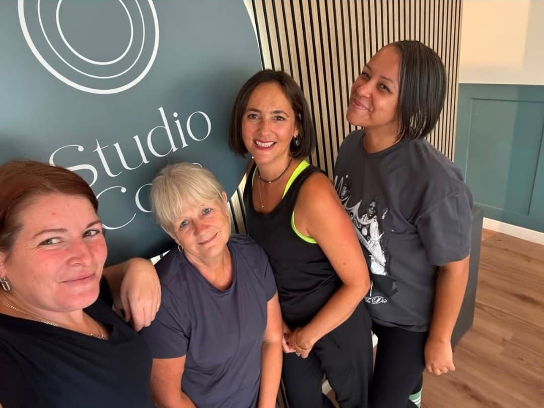 The Wednesday Morning Group at Studio Core, four members in front of the studio sign